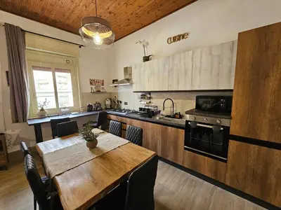 a kitchen with a wooden table and a dining room at Appartamento Vista Stazione in Palermo