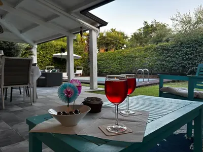 a table with two glasses of wine on a patio at Villa sole Sicily in Terrasini