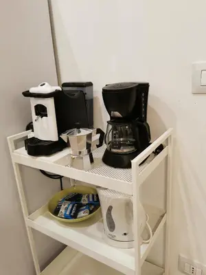 a shelf with a coffee maker and a coffeemaker on it at Casarino House Luxury Apartment in Palermo