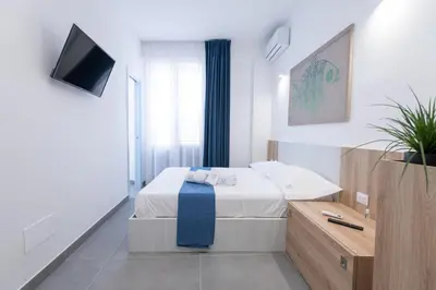 a bedroom with a bed and a television in it at Il Cortile Isola Casa Vacanze in Isola delle Femmine