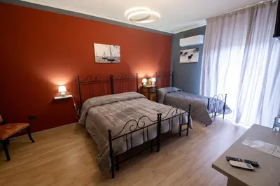two beds in a room with red walls at Room 112 Oltremare in Bagheria