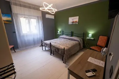 a bedroom with a bed in a green wall at Room 112 Oltremare in Bagheria