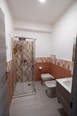 a bathroom with a shower and a toilet and a sink at Room 112 Oltremare in Bagheria