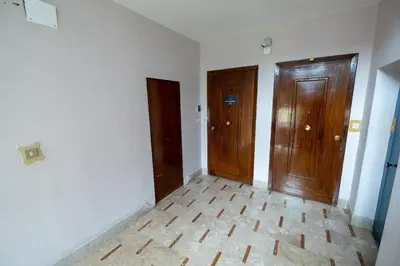 an empty room with two doors and a wooden floor at Room 112 Oltremare in Bagheria