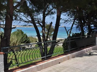 a park bench with a view of the ocean at CASE VACANZA PERLA DEL SUD in San Vito lo Capo