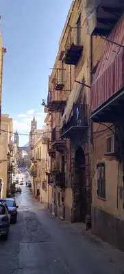 an alley with buildings and cars parked on a street at Dome Suite La Cupoletta in Palermo