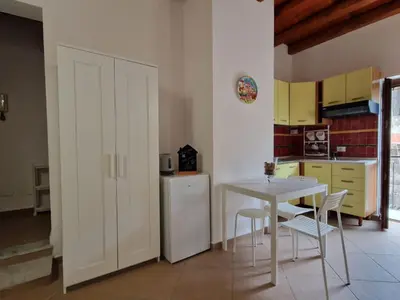 a kitchen with a table and a white refrigerator at Dome Suite La Cupoletta in Palermo