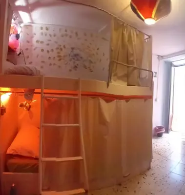 a bedroom with a bunk bed with a curtain at Ostello Exclusive Dependance in Palermo