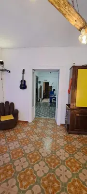 a living room with a couch and a television on a floor at Ostello Exclusive Dependance in Palermo