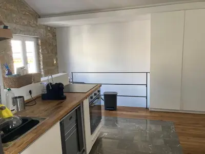 a kitchen with white cabinets and a wooden counter top at Casa levante in Palermo
