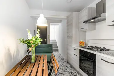 a kitchen with a wooden table with a vase of flowers at GuestHost - Alle Terrazze Blu - Mondello Sea View Apartment in Palermo
