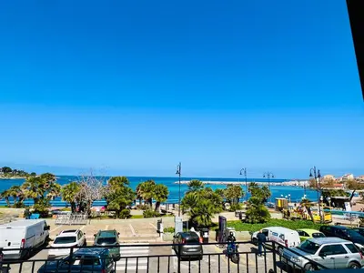 a parking lot with parked cars and the beach at Casa Nonna Anna in Palermo