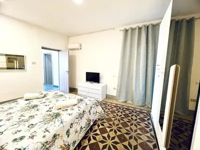 a hotel room with a bed and a television at Casa Nonna Anna in Palermo