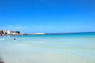 a person standing in the water on a beach at Casa Nonna Anna in Palermo