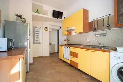 a kitchen with yellow cabinets and a washer at Solemar Sicilia - Villa Mariù in Palermo