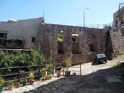 a brick building with a car parked in front of it at Affittacamere La Cartiera in Palazzo Adriano