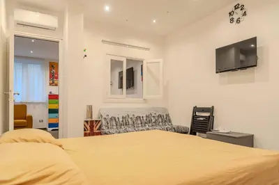 a bedroom with a bed and a tv on the wall at Casetta dei Colori - Apartament in Palermo