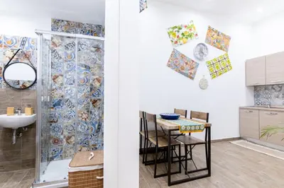 a bathroom with a sink and a table with chairs at Al Cortile del capo in Palermo