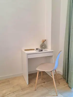 a white desk with a blue chair and a table at Downtown Maqueda in Palermo