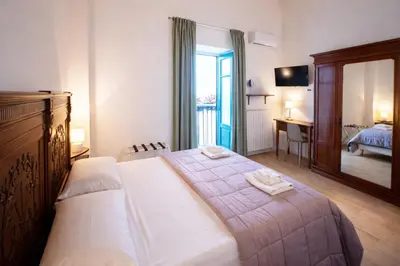 a bedroom with a bed with two towels on it at Downtown Maqueda in Palermo