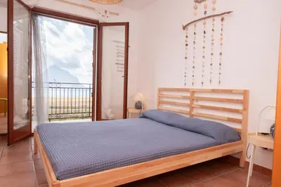 a bedroom with a bed and a large window at Casa Za Lisa con Vista Mare a Macari in Macari