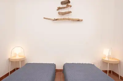 two beds in a room with two lamps and a shelf at Casa Za Lisa con Vista Mare a Macari in Macari