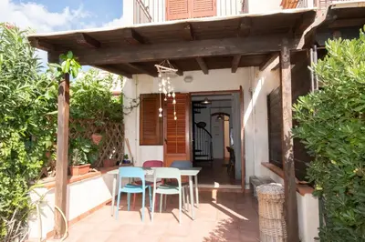 a patio with a table and chairs under a wooden pergola at Casa Za Lisa con Vista Mare a Macari in Macari