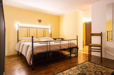 a bedroom with a bed and a chair at Hola House alla Magione in Palermo