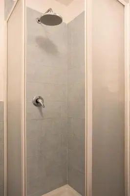 a bathroom with a shower with a glass door at Hola House alla Magione in Palermo