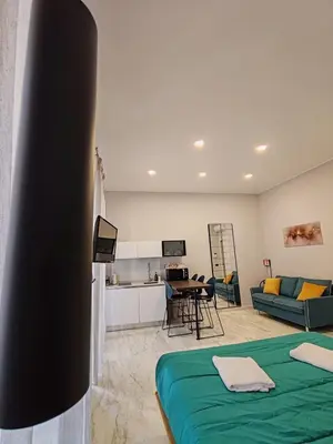 a living room with a bed and a kitchen at Lily Apartments in Palermo