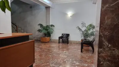 a lobby with two chairs and two plants at Palermo Belmonte Florio in Palermo