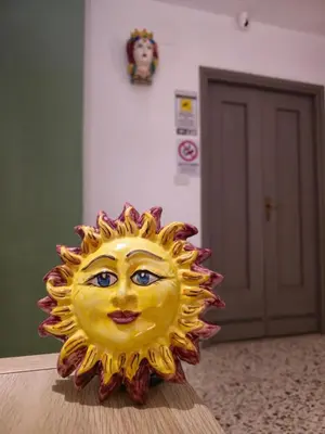 a statue of a sun with a face on a table at Palermo Belmonte Florio in Palermo