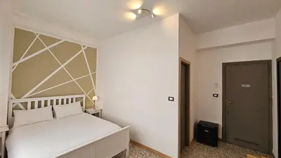 a bedroom with a white bed with a white headboard at Palermo Belmonte Florio in Palermo