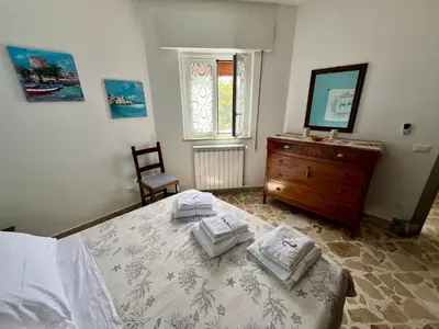 a bedroom with a bed and a dresser and a window at La casa di Gisa&Laura Lido di Mondello spiaggia in Palermo