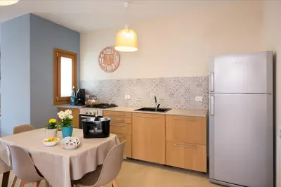a kitchen with a table and a refrigerator at Casa vacanze near airport in Cinisi