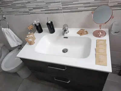 a bathroom with a sink and a mirror and a toilet at Lannari 176 Casa vacanze Bagheria in Bagheria