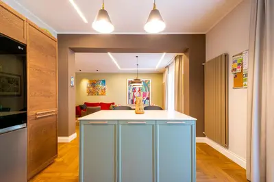 a kitchen with blue cabinets and a living room at Casa Alexandra - Luxury & Design in Castellammare del Golfo