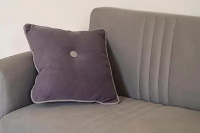 a purple pillow sitting on a gray couch at Capo Zafferano Apartments in Santa Flavia