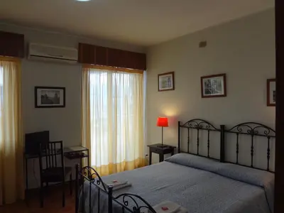 a bedroom with a bed and a table and a chair at Casa Riccio in Palermo