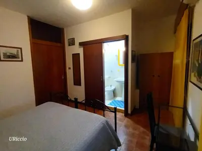 a bedroom with a bed and a bathroom with a toilet at Casa Riccio in Palermo