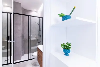 a bathroom with a toilet and a plant on a shelf at Sofia’s Studio at Mondello in Palermo