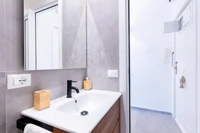 a bathroom with a sink and a mirror at Sofia’s Studio at Mondello in Palermo