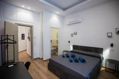 a bedroom with a bed with blue pillows on it at Maison La Lumia in Palermo