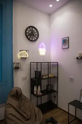 a room with a clock and a shelf with a cupcake at Maison La Lumia in Palermo