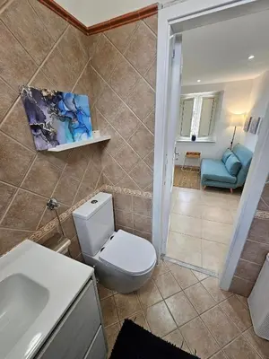 a bathroom with a toilet and a sink and a couch at Terrazza Ballarò in Palermo
