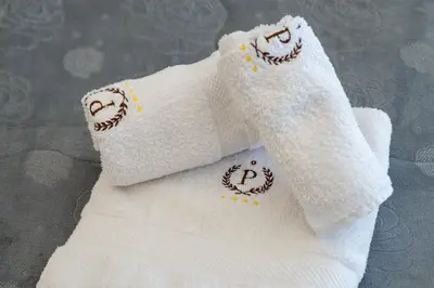 two white towels with smile faces embroidered on them at Federico 70 Acquamarina Luxury in Palermo