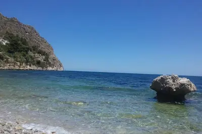 a large rock in the water near a beach at Relaxing seahouse in Santa Flavia