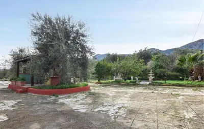a park with a tree and a building at Lovely Home In Altavilla Milicia in Altavilla Milicia