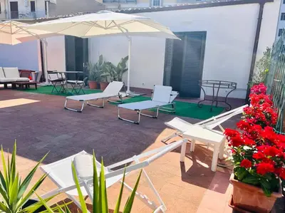 a patio with chairs and umbrellas on a building at Loft Palermo Centro con terrazzo. Free parking in Palermo