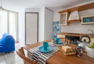 a kitchen with a wooden table with blue dishes on it at Appartamento del centro CIR 19081005C217988 in Castellammare del Golfo
